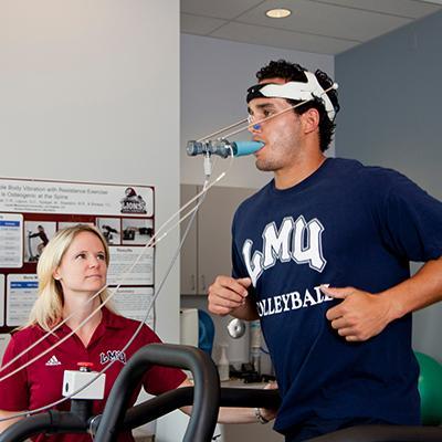 Student exercising in physiology lab with professor.