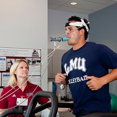 Student exercising in physiology lab with professor.