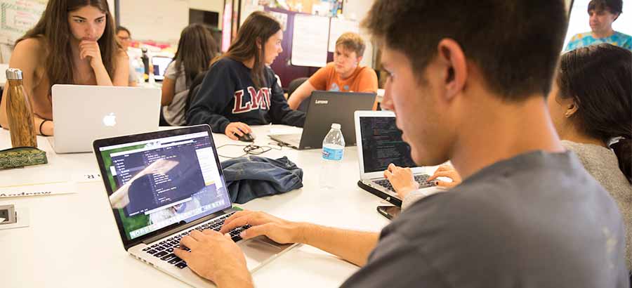 Computer science students working on laptop computers