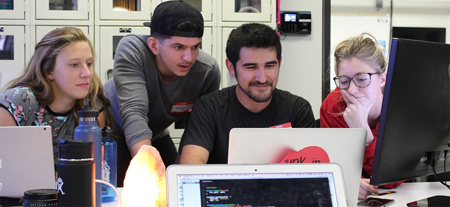 four computer science students looking at screen