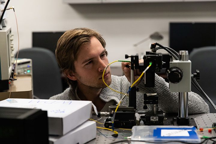 A student fine-tuning a piece of lab equipment