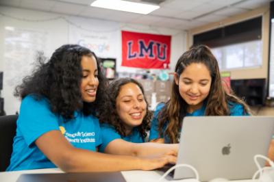 Three students working on a computer.