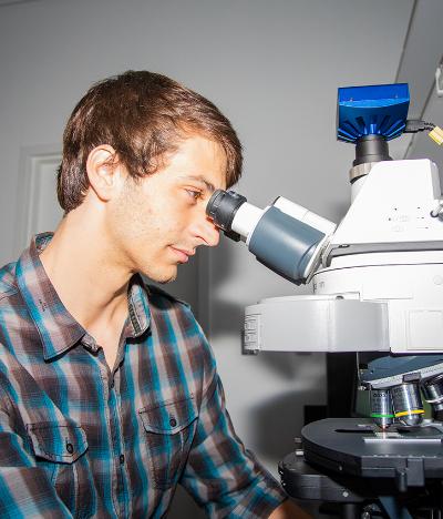 Student looking into microscope.