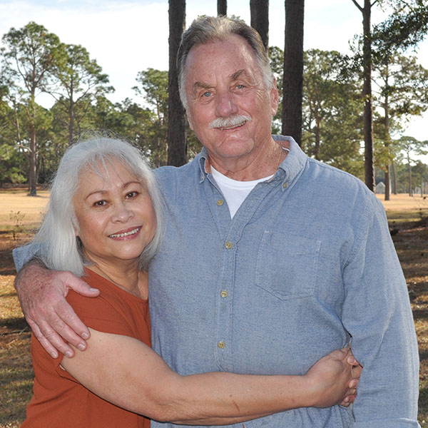man and woman embracing standing outdoors