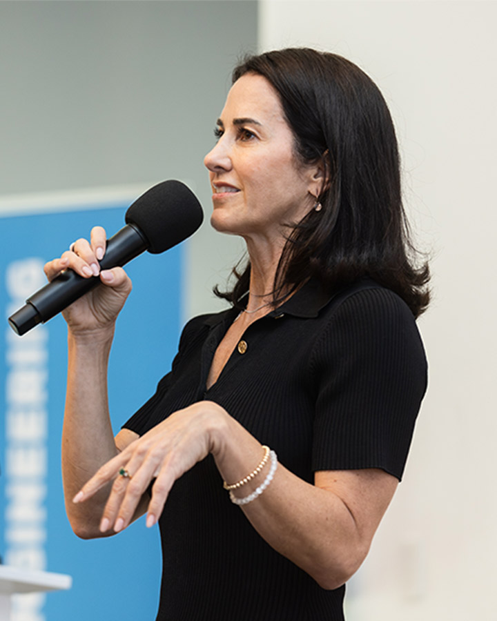 Jackie Space holding a microphone at an LMU Speaking engagement